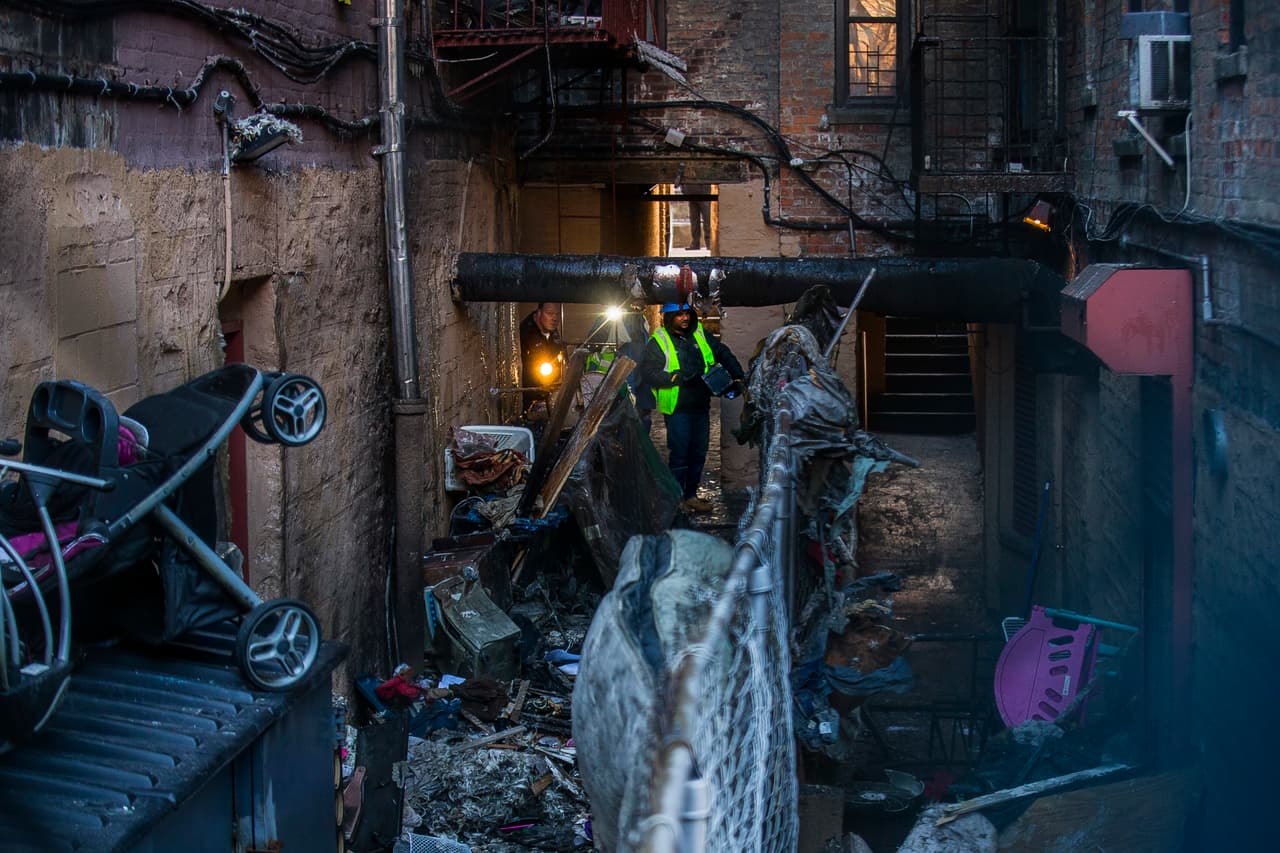 La policía y los bomberos inspeccionan el edificio incendiado y los alrededores. Se trata del incendio residencial más mortífero de la ciudad de Nueva York en décadas.