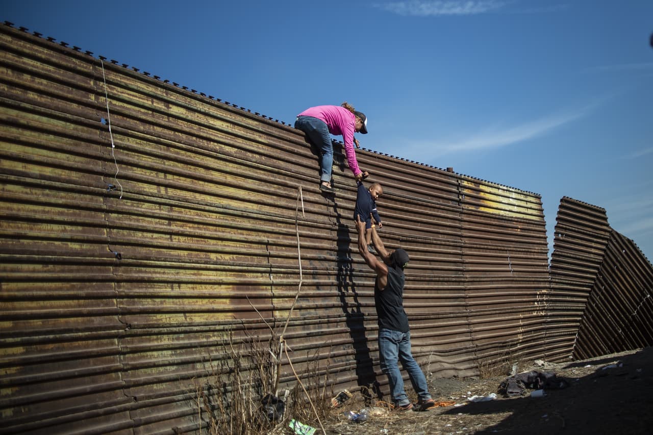 <b>Familia sobre el muro. </b>Las largas filas en las oficinas de EEUU en la frontera y 
<a href="https://www.univision.com/noticias/indocumentados/por-las-noches-se-oye-llorar-a-la-gente-las-duras-condiciones-que-soportan-los-migrantes-de-la-caravana-en-tijuana">las condiciones de los refugios en Tijuana provocaron que el cruce ilegal de la frontera se convirtiera en una opción para algunos de los migrantes que desean solicitar asilo</a>. En la fotografía, tomada el 25 de noviembre de 2018, varias familias de centroamericanos treparon la valla fronteriza cerca del cruce de El Chaparral, en Tijuana.