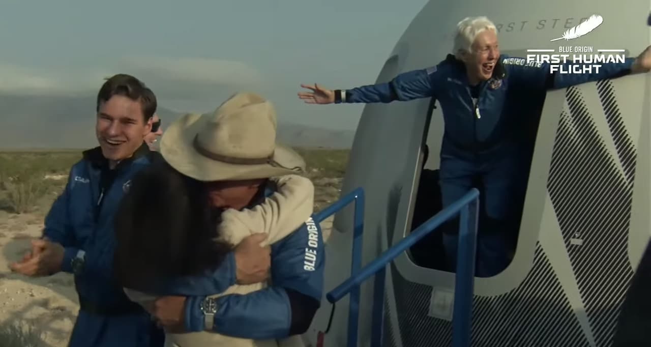 Jeff Bezozen primer plano y en la puerta de la cápsula Mary Wallace Funk, una pionera en la formación de astronautas en los años sesenta, pero nunca tuvo la oportunidad de volar al espacio.