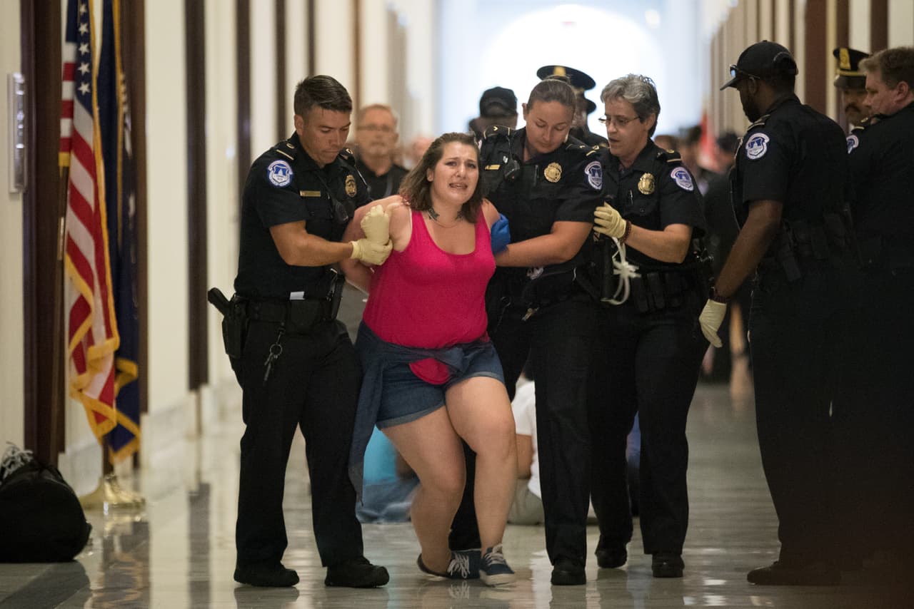 <b>Contra la reforma de salud (28 de junio).</b> Una manifestante es arrestada frente a las oficinas de senadores republicanos en el congreso. Parte de las decenas de activistas que 
<b><a href="https://www.univision.com/noticias/politica/el-voto-que-salvo-a-obamacare-la-rebelion-de-john-mccain-contra-trump-que-suena-a-venganza">protestaron por la reforma a obamacare impulsada por Donald Trump, pero que aún logró pasar en el Senado. </a></b>