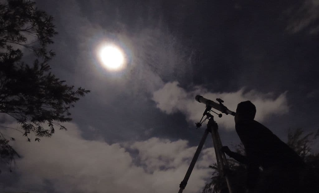 Este hombre divisa el eclipse lunar con un telescópio en Bogotá, Colombia.