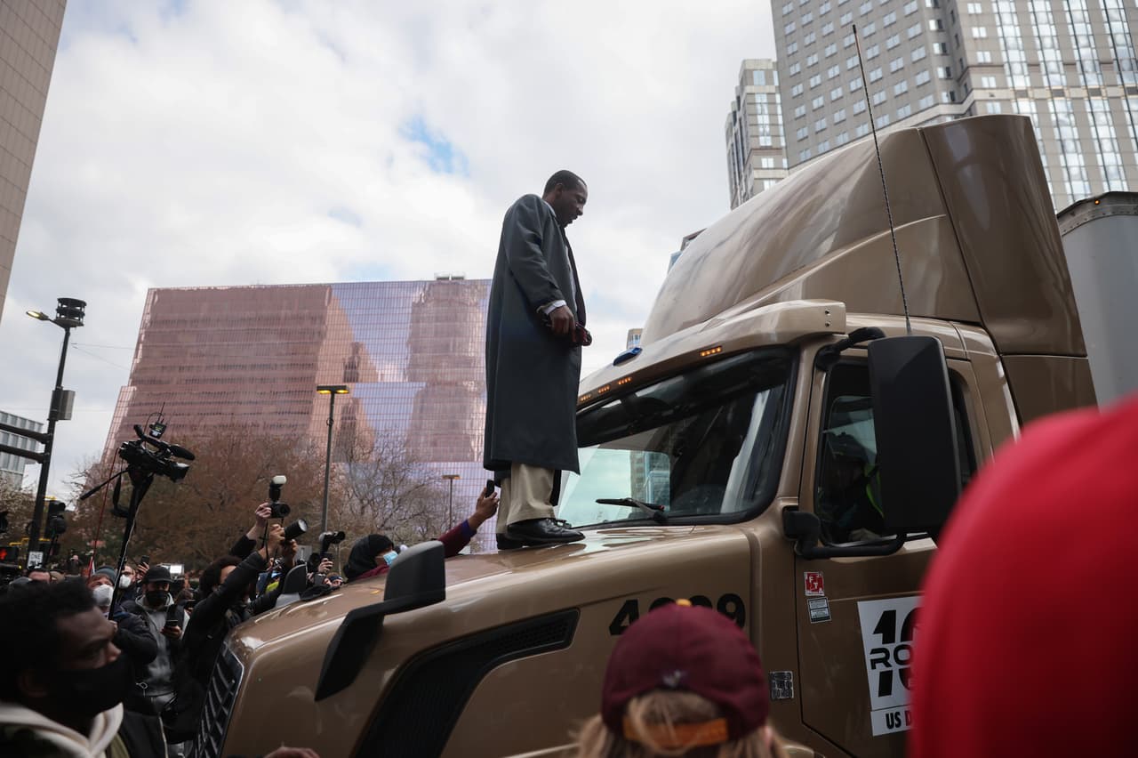 Un hombre de pie sobre un trailer que quiso abrirse paso entre la multitud congregada en Minneapolis.