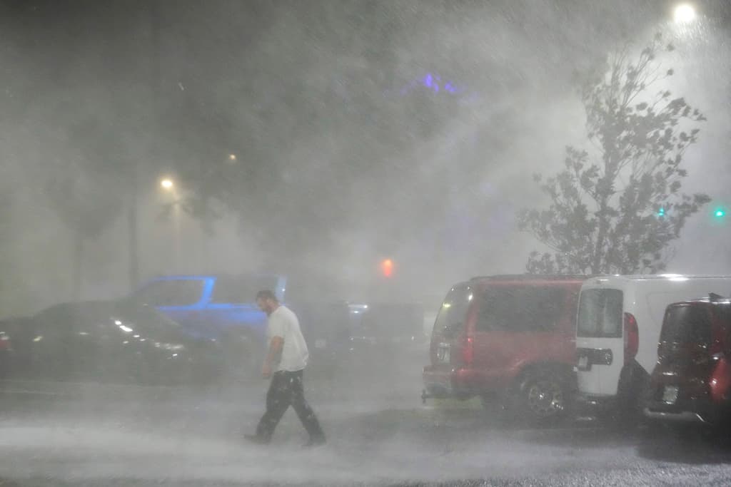 Un hombre camina por un estacionamiento en el exterior de un hotel en Tampa antes del paso del huracán Milton, el miércoles. (AP Foto/Julio Cortez)