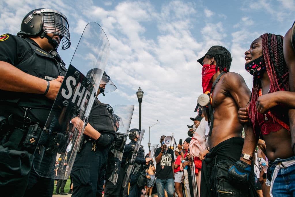 Los policías respondían al lanzamiento de botellas de agua y de fuegos artificiales por parte de los manifestantes, que horas antes gritaban a la cara de los agentes: "¡sin justicia no hay paz!" y "di su nombre: Jacob Blake".
