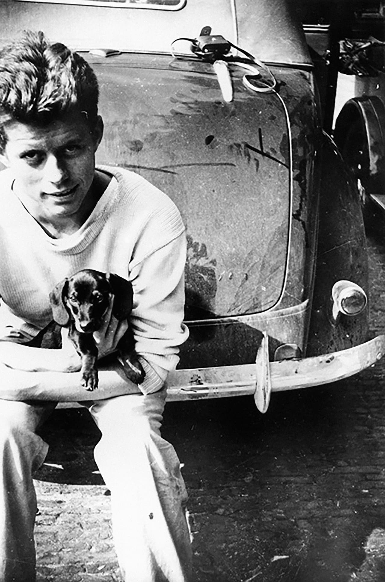 El futuro presidente junto a ‘Dunker’, un perro 
<i>dachshund</i> en La Haya, Países Bajos (1937). Con 20 años de edad y ya matriculado en Harvard, JFK recorrió Europa. En este continente ya había estado antes, y regresaría al año siguiente junto a su hermano mayor a trabajar con su padre, seleccionado por Franklin Delano Roosevelt como embajador de EEUU en Londres.