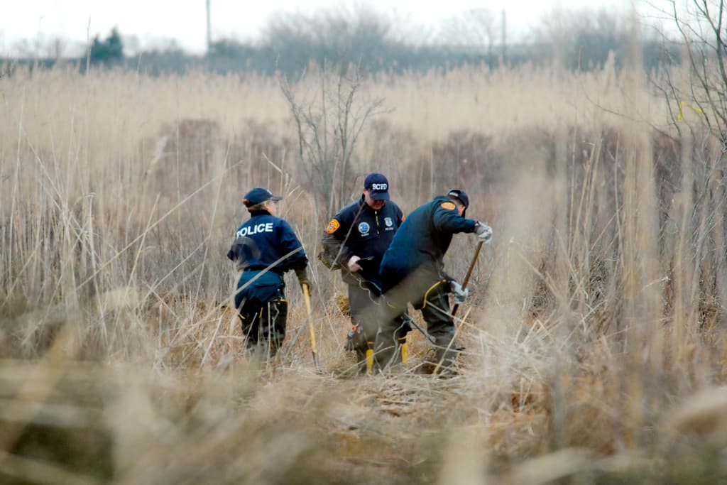 Investigadores en una zona de Oak Beach donde hallaron restos humanos de varias mujeres.