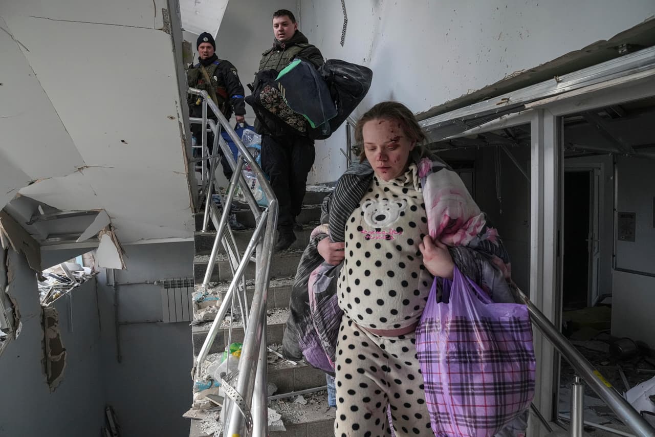Una mujer embarazada, herida tras el bombardeo, baja las escaleras del hospital atacado por las fuerzas rusas. "Un hospital materno infantil. ¿Cómo representaba una amenaza para la Federación Rusa?", se preguntó el presidente de Ucrania durante su condena al ataque.