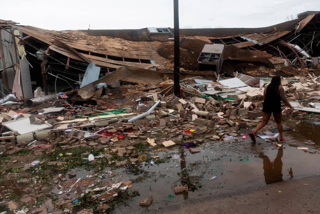 Una persona pasa junto a los restos de un edificio completamente destruido en Lake Charles, que recibió los fuertes vientos de Laura, tras tocar tierra cerca de allí como un poderoso huracán categoría 4.