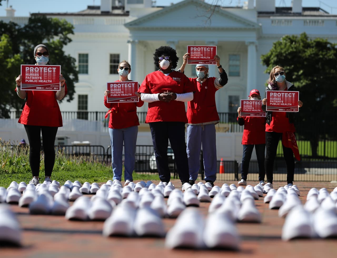 La pandemia expuso la vulnerabilidad de los sistemas de salud en todo el mundo, donde las enfermeras junto a los médicos continúan arriesgando su vida. En la fotografía un grupo de enfermeras protestan frente a la Casa Blanca para exigir más equipos de protección contra el coronavirus, y compensaciones por la carga extraordinaria de trabajo, el 7 de mayo.
<br>