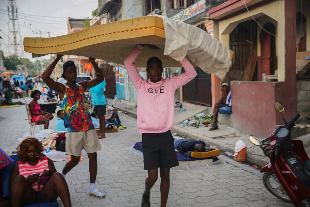Un hombre carga un colchón por una calle de Les Cayes. Allí, el impacto también fue considerable, incluyendo el colapso de un hotel de varias plantas.
<br>
<br>"Los hospitales están al límite y no están aceptando a algunas personas", dijo a Univision Noticias Morgan Wienberg, una joven canadiense que fundó el proyecto Little Footprint, Big Steps, que provee casas para niños pobres o abandonados.