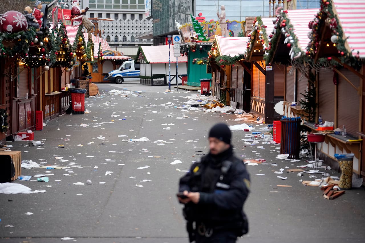 Un agente de policía se encuentra en un mercado navideño acordonado, donde un automóvil atropelló a una multitud el viernes por la noche, en Magdeburgo, Alemania, el sábado 21 de diciembre de 2024.