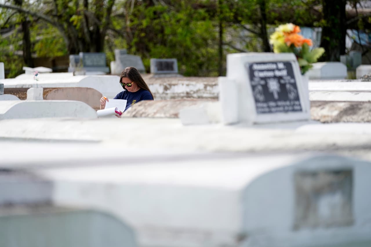 Christine Halling examina una de las tumbas afectadas. La identificación de los restos desenterrados por las 
<a href="https://www.univision.com/temas/tormentas-tropicales">tormentas</a> es complicada y en ocasiones deben usarse registros dentales o pruebas de ADN.