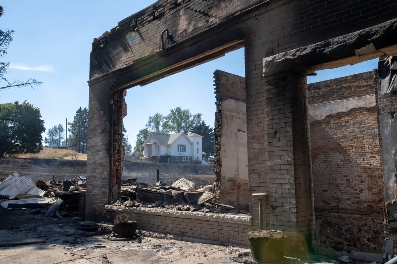 Un edificio comercial destruido por un incendio forestal en Malden, Washington. Atrás se ve la Iglesia de la Comunidad Congregacional. "Vivimos en un mundo nuevo. Ya no es el Washington de antes", expresó el gobernador Inslee al denunciar al 
<b><a href="https://www.univision.com/temas/cambio-climatico">cambio climático</a></b> como principal agente de este tipo de desastre.