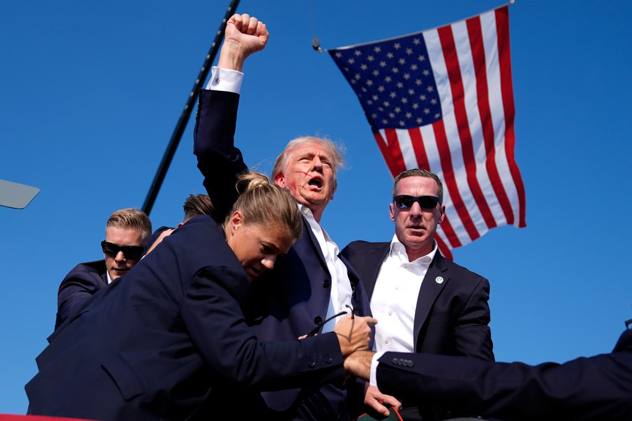 Trump levanta el puño y grita "pelea" mientras lo ayudan a bajar del escenario en un evento de campaña en Butler, Pensilvania, el sábado 13 de julio de 2024. Segundos antes, un joven disparó contra Trump, con el objetivo de matarlo. Una bala terminó rozándole la oreja, hiriéndolo levemente. 
<a href="https://www.univision.com/noticias/elecciones-en-estados-unidos-2024/servicio-secreto-necesita-una-sacudida-luego-del-intento-de-asesinato-de-trump">El ataque mató a un asistente del mitin, Corey Comperatore, de 50 años.</a> Esta foto se volvió icónica para los seguidores del republicano.