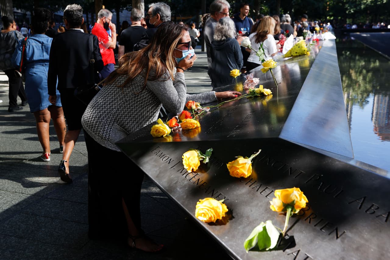 Una mujer llora en el Monumento del 9/11 en Nueva York, donde dos fosos inmensos donde estuvieron las Torres Gemelas y por los que caen cascadas que caen por centenares de pies conforman un mausoleo que invita al recogimiento y respeto en memoria de los fallecidos.