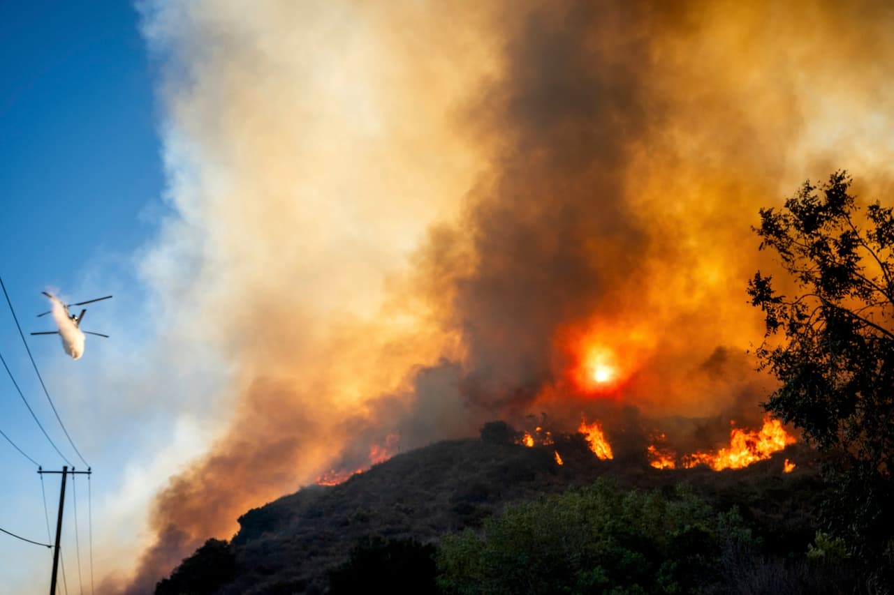 Equipos de bomberos, apoyados por helicópteros, protegen viviendas en terrenos difíciles al noreste del incendio, cerca de Santa Paula, donde residen más de 30,000 personas.