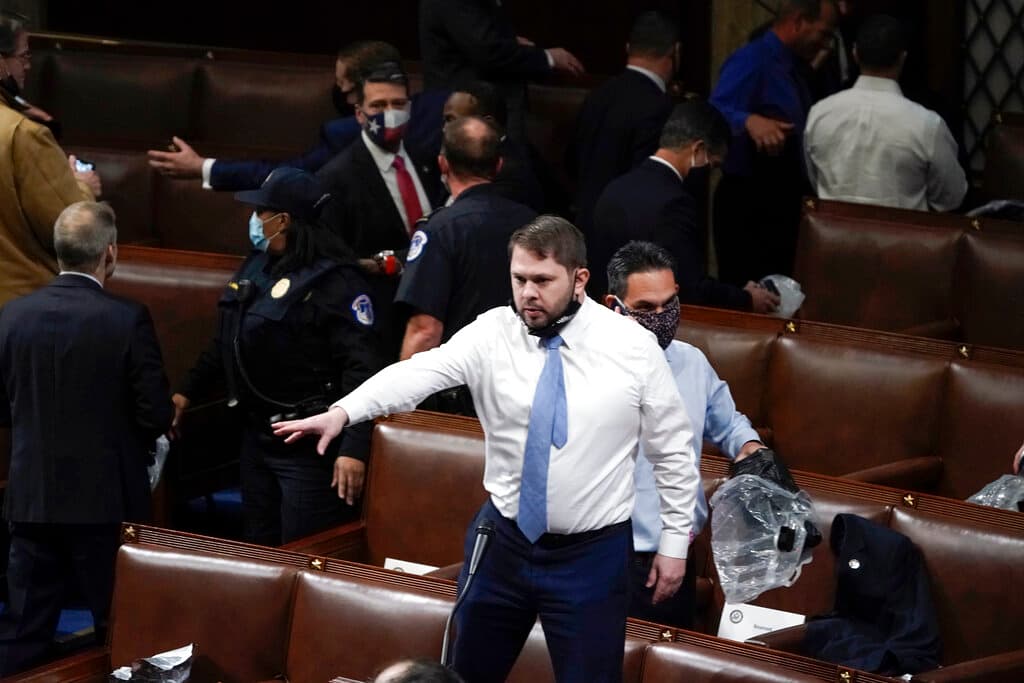 ARCHIVO - El representante Rubén Gallego, demócrata por Arizona, se para en una silla mientras los legisladores se preparan para evacuar la sala mientras los alborotadores intentan ingresar a la Cámara de Representantes en el Capitolio de EE. UU. el miércoles, 6 de enero de 2021, en Washington.