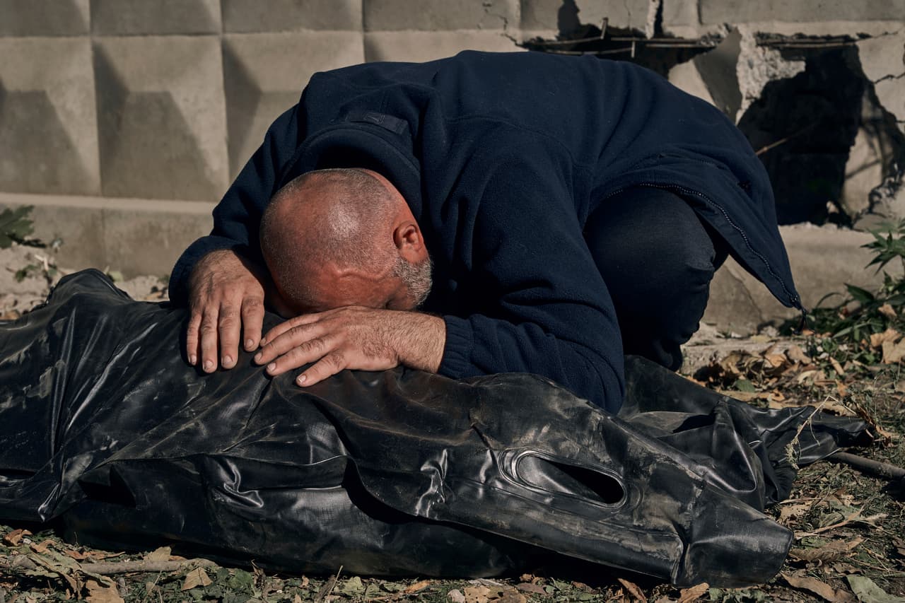 Un hombre llora sobre el cadáver de su primo, víctima de uno de los bombardeos, en una zona cercana a Kiev, Ucrania.