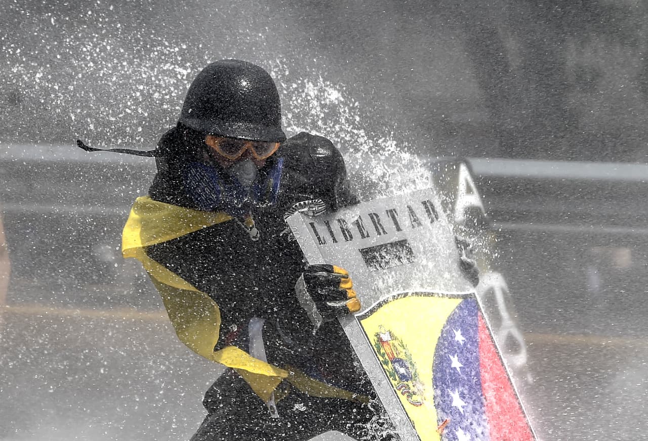El ministro también informó que Castillo fue asesinado con un arma de fuego. Un manifestante recibe un chorro de agua de la la policía.