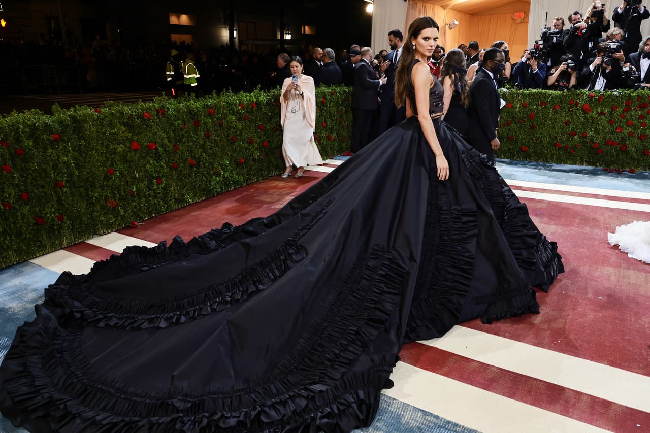 <b>Kendall Jenner</b>, por su parte, optó por un look mucho más voluminoso: un vestido de negro de dos piezas de Prada. Con el top se unió a la tendencia de las transparencias negras y con la falda, a la de las colas largas. El detalle que más llamó la atención de su estilo fueron las cejas decoloradas.