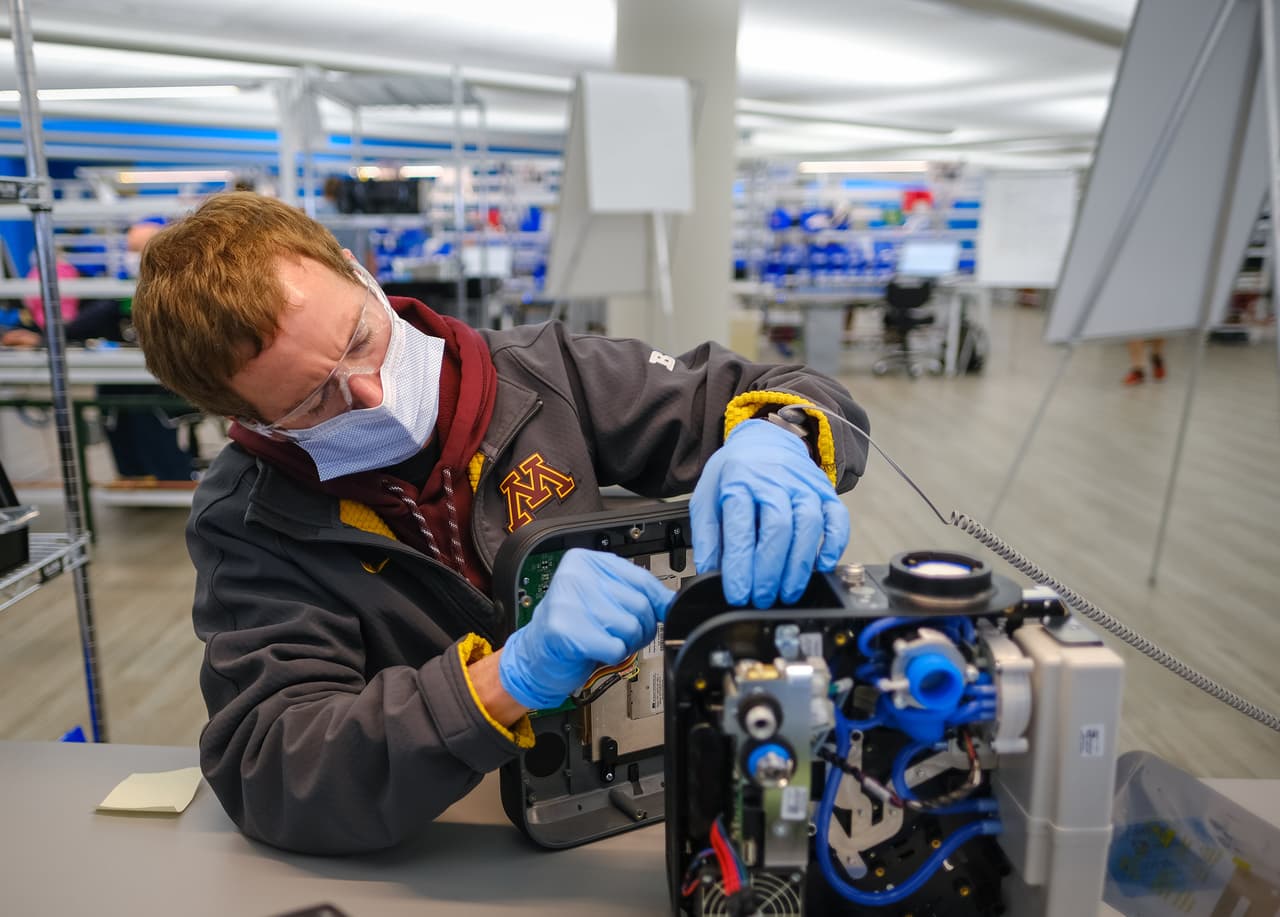 <b>Fábricas que cambiaron de ramo temporalmente.</b> Tal como pasa en las guerras, miles de compañías en todo el mundo modificaron sus líneas de producción. Automotrices fabrican respiradores, destiladoras de licor crean desinfectantes de manos y fábricas de ropa ahora hacen mascarillas. En la fotografía, un trabajador de General Motors trabajando en un respirador en Kokomo, Indiana, a principios de abril.