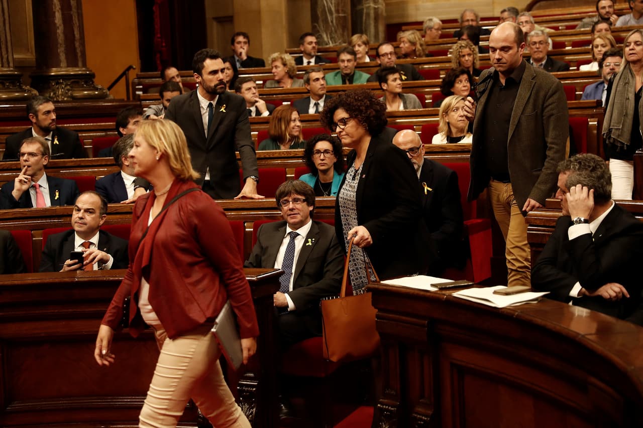 La moción aprobada en el parlamento regional en Barcelona fue boicoteada por los partidos de la oposición, cuyos miembros abandonaron la sede del parlamento. En la fotografía el presidente de Cataluña Carles Puigdemont mira salir a los parlamentarios opuestos a la independencia.