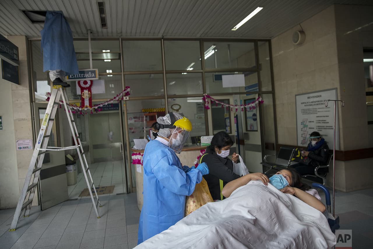 Una enfermera 
<b>recibe a una futura madre contagiada por el nuevo coronavirus en un puesto de control de entrada </b>instalado fuera de la entrada de emergencia del instutito.