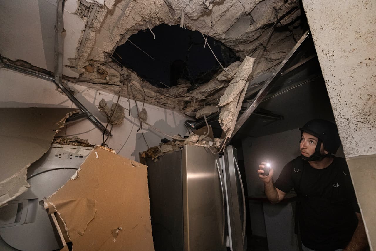 Un hombre israelí inspecciona los daños a una casa que fue alcanzada por un cohete disparado desde la Franja de Gaza, en Ashkelon, en el sur de Israel, el 12 de mayo. 
<a href="https://www.univision.com/noticias/mundo/domo-hierro-desigualdad-conflicto-arabe-israeli-fotos-fotos"><u>La mayoría de los proyectiles lanzados por Hamas son interceptados por el sistema de defensa de Israel</u></a>.