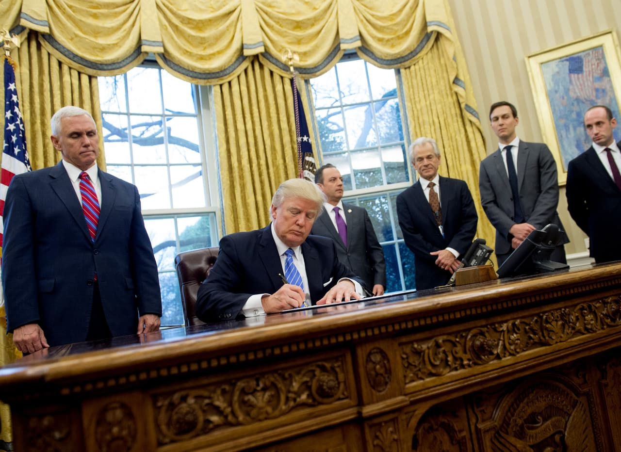 Stephen Miller (en la derecha) en el Despacho Oval mientras Trump firma una orden ejecutiva.