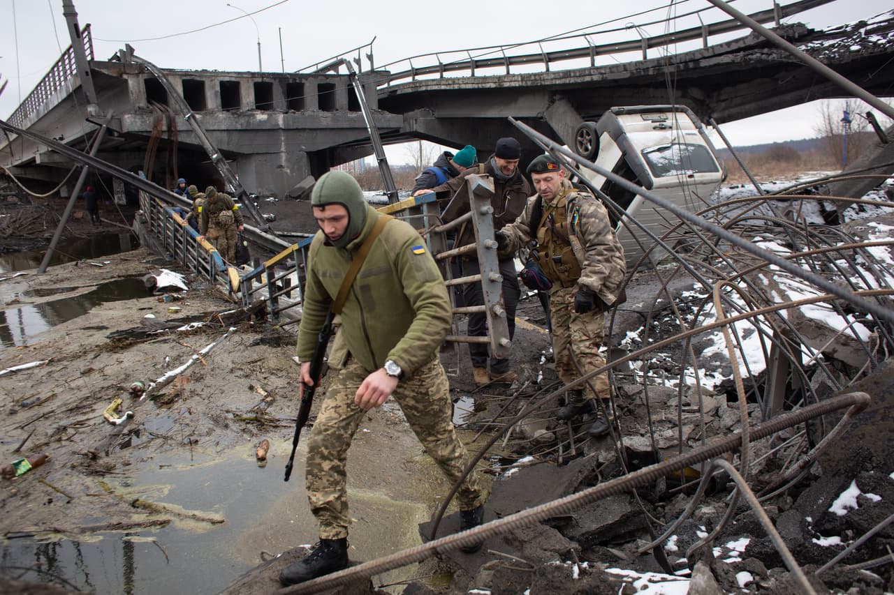 Un militar ucraniano camina cerca de un puente destruido por bombardeos en Irpin. A medida que avanza en su invasión, Rusia también sufre el castigo de severas sanciones acordadas por EEUU, Europa y países aliados. Este martes, Sberbank, el mayor banco de Rusia que es controlado por el Estado, decidió abandonar el mercado europeo ante el impacto en sus filiales en esa región.