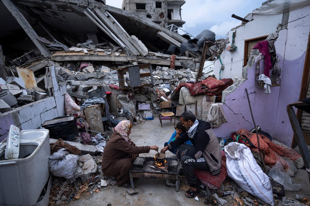 Miembros de la familia Al-Rabaya 
<a href="https://www.univision.com/noticias/mundo/guerra-israe-hamas-plazo-ramadan-hamas-liberar-rehenes-amenaza-ataques-rafah-corte">rompen el ayuno durante el mes sagrado musulmán del Ramadán</a> frente a su casa, destruida por un ataque aéreo israelí, en Rafah, Gaza, el 18 de marzo de 2024.