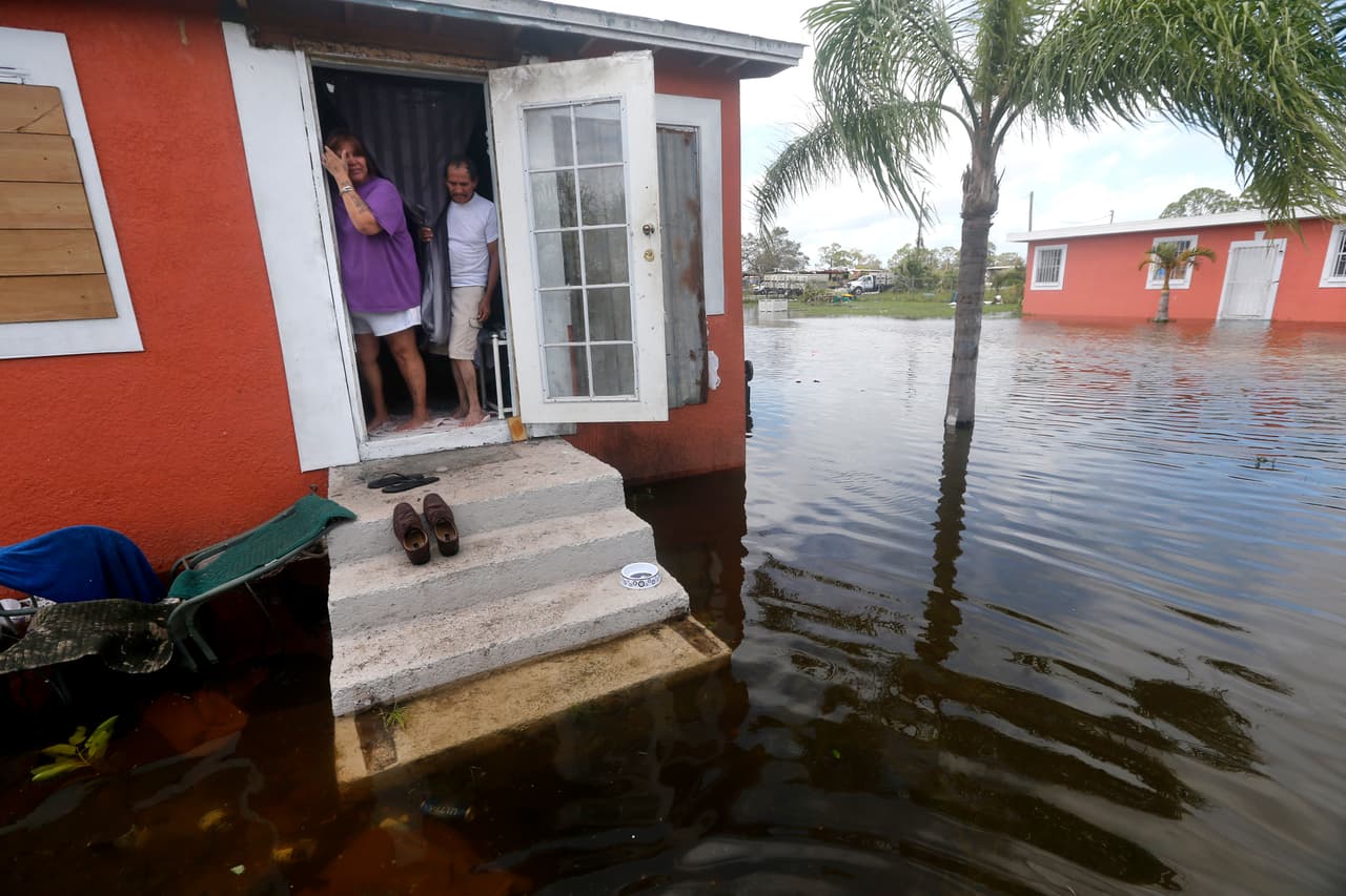 Quintana y Liz Perez miran a la inundación frente a su casa en Immokalee. Huir de Irma no era una opción para los que no tenían transporte para llegar a un refugio, no podían permitirse el combustible al norte y no podían arrendar una habitación de hotel. Los costes asociados con la limpieza o encontrar un lugar nuevo para vivir los han dejado más al límite que nunca.