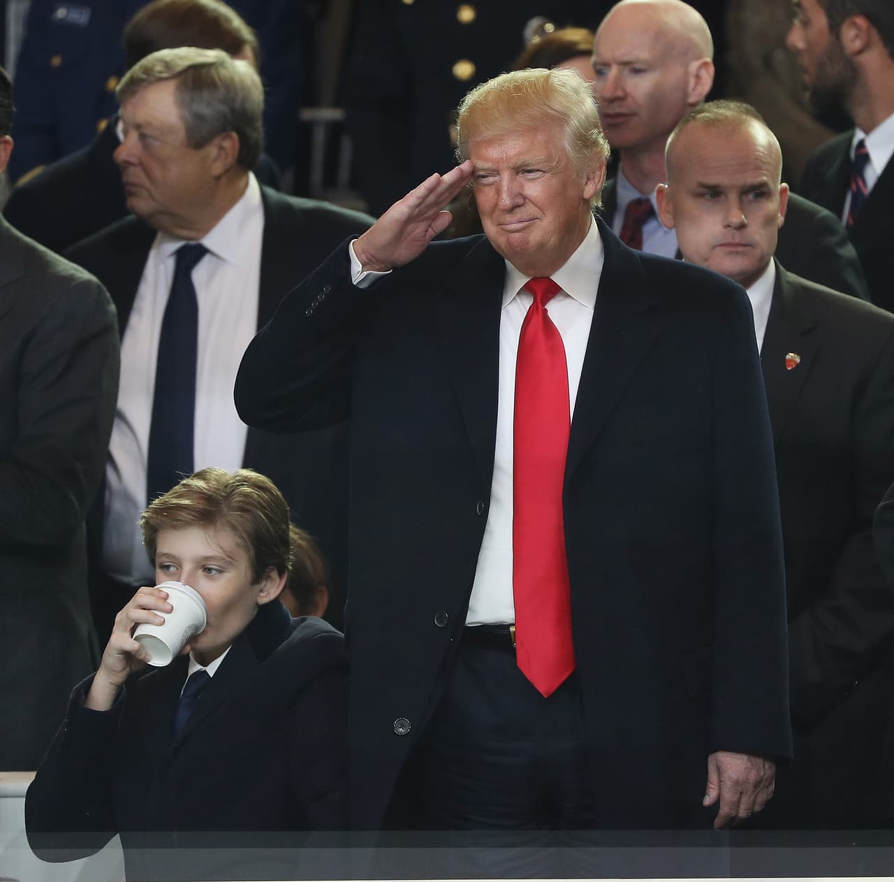 El presidente de Estados Unidos saluda a los participantes en el desfile Junto a su hijo Barron.