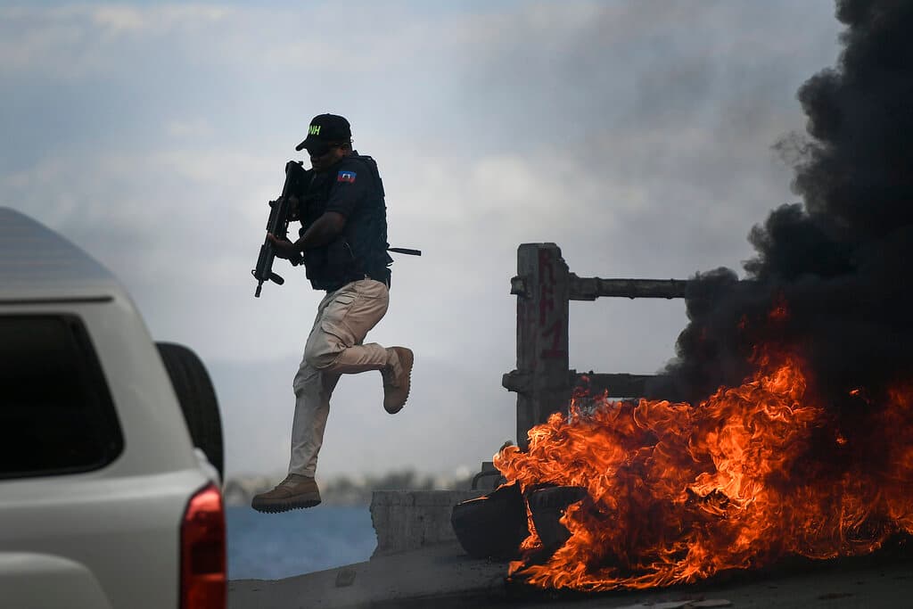 Un agente de policía abandona su vehículo durante una protesta este jueves en Cabo Haitiano, que se tornó violenta y en la que los manifestantes exigían justicia para el asesinado presidente Jovenel Moise.
