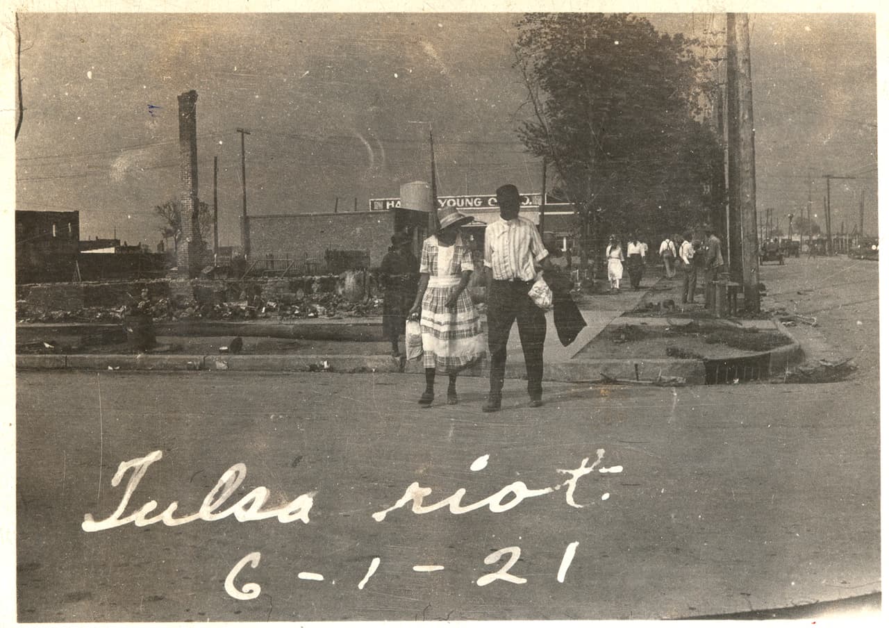 <b>Las ruinas de la violencia.</b>
<br>
<br>Una pareja de afroestadounidenses caminando con los escombros aún humeantes al fondo.
<br>