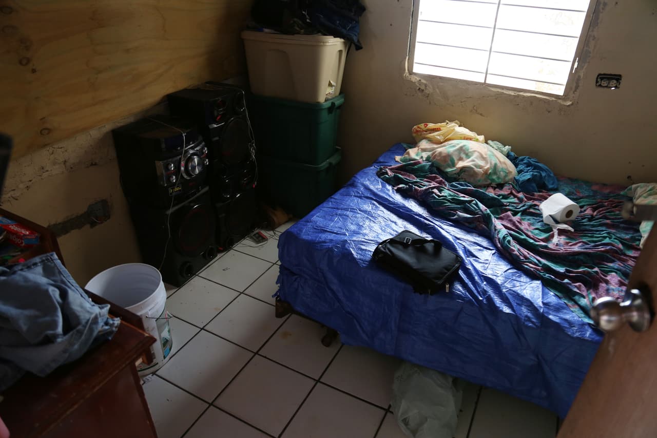Nancy Calderón y Domingo Pizarro duermen sobre un colchón empapado de agua, envuelto y protegido por un toldo azul de plástico.