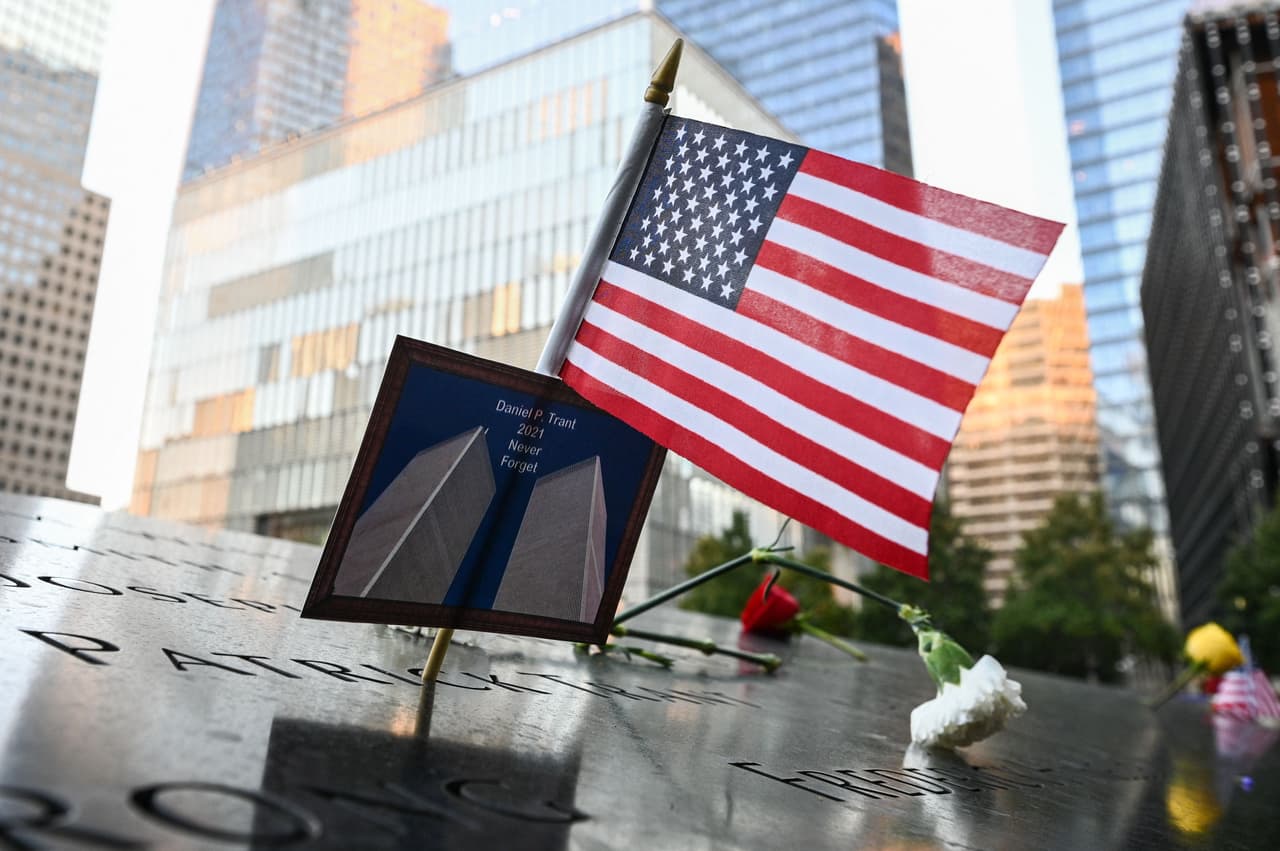 Una bandera estadounidense junto con una foto de las desaparecidas Torres Gemelas colocadas en el nombre de Daniel P. Trant, un operador financiero que murió el 
<a href="https://www.univision.com/noticias/20-anos-atentados-9-11/atentados-del-11-de-septiembre-de-2001-9-11-torres-gemelas-20-anos-despues">11 de septiembre,</a> durante la ceremonia de homenaje.