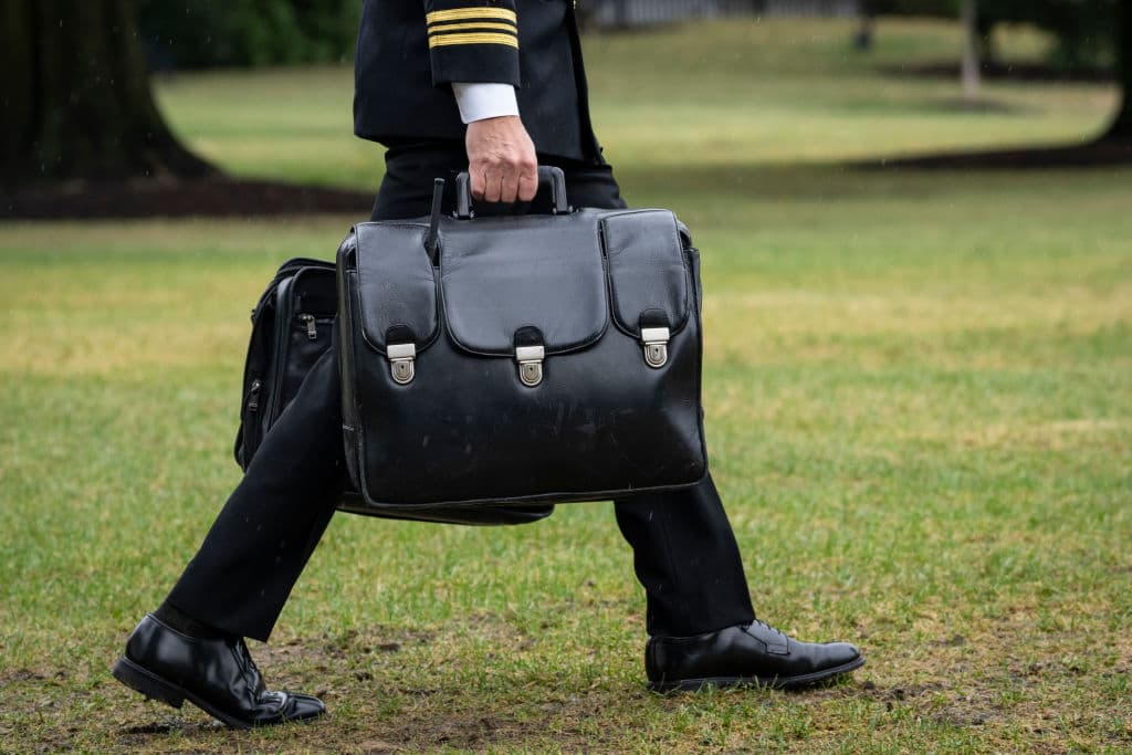 Escoltado para el viaje del presidente estadounidense, un oficial llevó los bultos conocidos como "nuclear football". Estos contienen códigos de lanzamiento 
<b><a href="https://www.univision.com/noticias/biden-responde-a-la-amenaza-de-putin-una-guerra-nuclear-no-se-puede-ganar-video" target="_blank">para armas nucleares</a></b>.