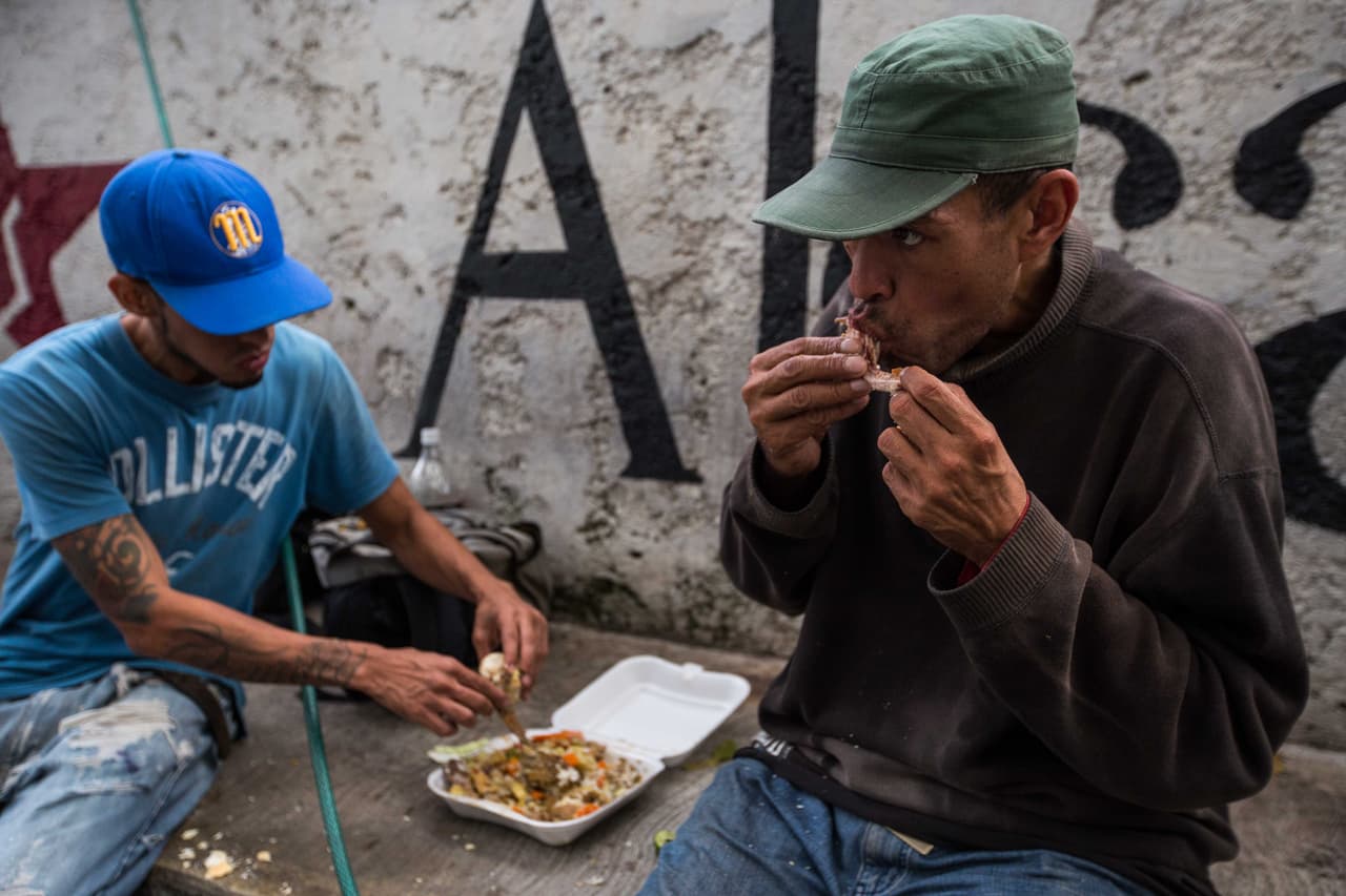 Carlos Alberto Perdomo tiene 42 años, los cuatro últimos viviendo en la calle. Como tiene antecedentes penales por un robo hace 28 años, le cuesta conseguir un trabajo formal. Se gana la vida como "parquero": cuidando carros ajenos que estacionan en las calles de Caracas, donde los asaltos son comunes y frecuentes. El dinero de las propinas que recibe solo le alcanza para comprar un pan al día, después de hacer la fila respectiva. 
<b>El estómago lo llena con basura</b>. "Y esto no me gusta, pero qué voy a hacer. Esto ya se ha convertido como un vicio, sabes? Como una modalidad para subsistir, porque es mejor hacer esto que robar, ¿no crees tú?", dice Perdomo.
