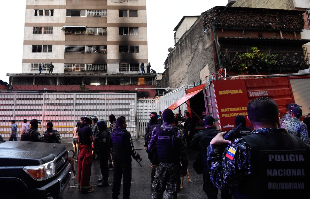 Fuerzas de seguridad y miembros del Servicio Bolivariano de Inteligencia Nacional (Sebin) visitan un edificio cercano después de que se escuchara una explosión.