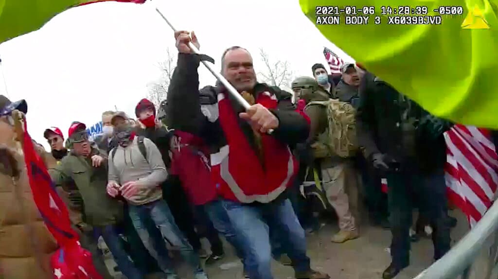 En esta imagen tomada del video de una cámara corporal de un agente del Departamento de Policía Metropolitana se ve a Thomas Webster, de chaqueta roja, durante la insurrección en el Capitolio el 6 de enero de 2021.