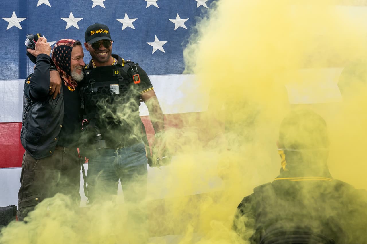 Uno de los líderes del Proud Boys, Enrique Tarrio (derecha), abraza a un compañero 
<b>durante el mitin que reunió a cientos de manifestantes del grupo de extrema derecha en Portland. </b>