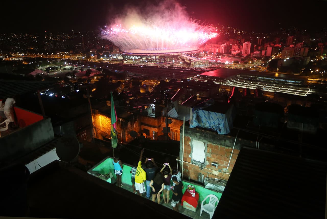 <b>Fantasía en la favela.</b> Una familia mira desde un barrio pobre de Río de Janeiro, Brasil, los fuegos artificiales lanzados durante la inauguración de los Juegos Olímpicos en el estadio Maracaná. 5 de agosto de 2016.