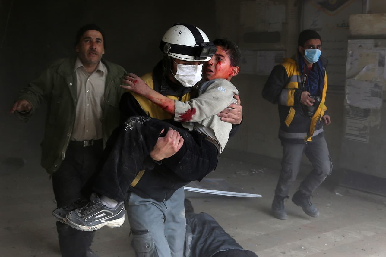8 de febrero. Un miembro de la defensa civil siria rescata a un niño herido de entre los escombros de la ciudad rebelde de Jisreen.