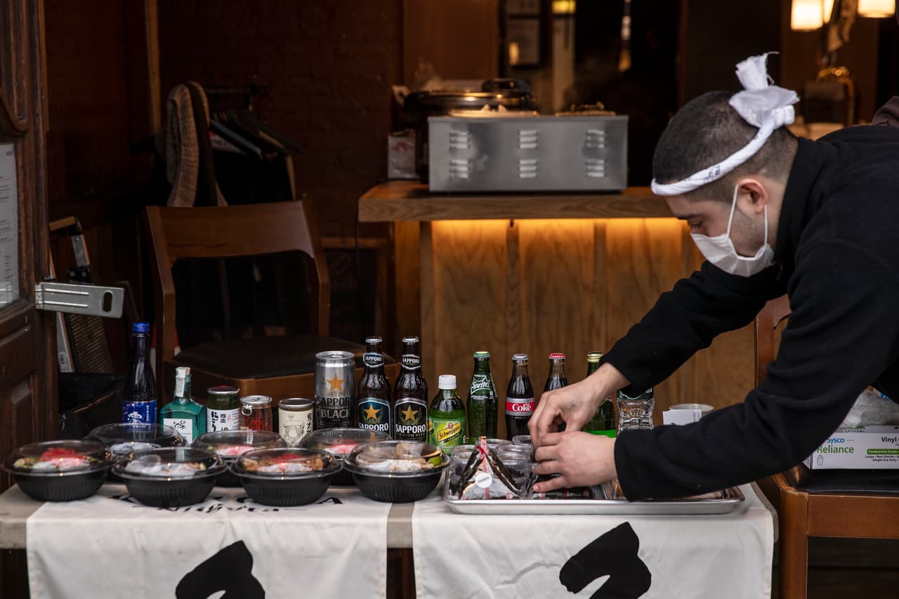 <b>Cocteles para llevar.</b> Los bares y restaurantes en la ciudad de Nueva York fueron cerrados por la ciudad hace días, pero se les permitía vender comida y alcohol para llevar. El 19 de marzo la autoridades estatatel ordenaron la cuarentena para todos los residentes, siguiendo el ejemplo que dio California. En la fotografía el encargado de un bar de Manhattan vendiendo cócteles frente al establecimiento.
