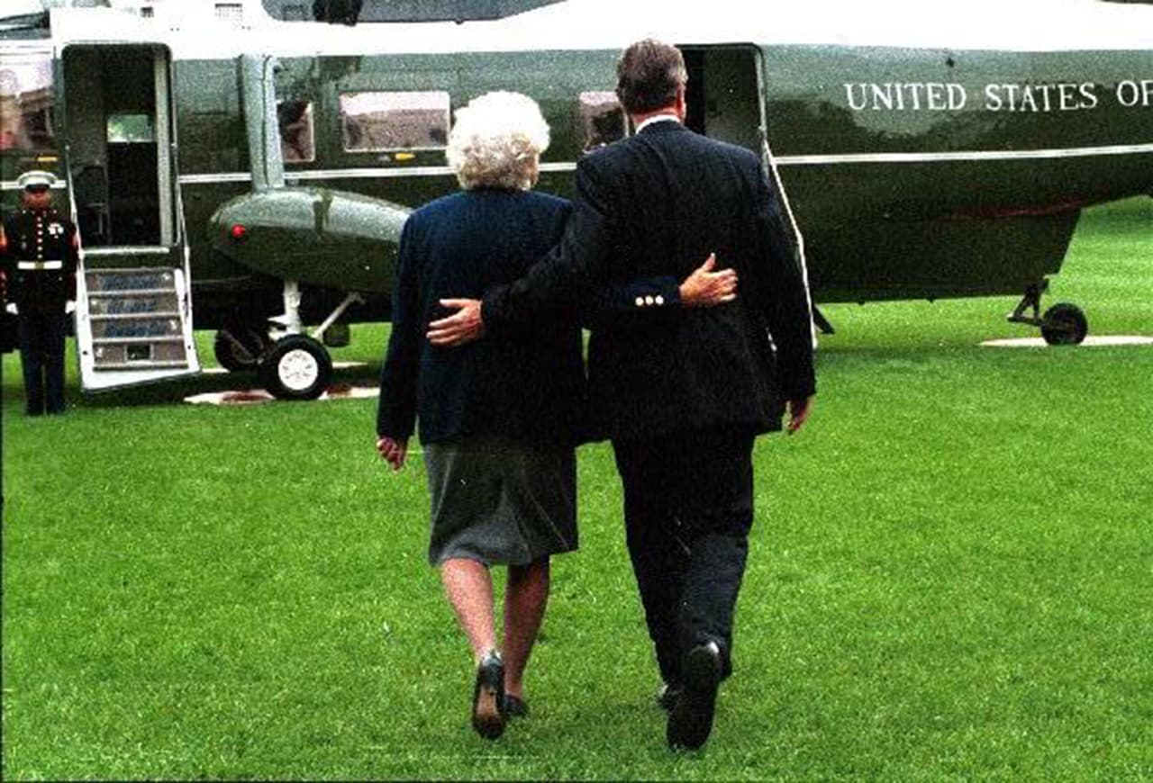 La pareja presidencial, George H.W. Bush y Barbara Bush, caminan abrazados hacia el Marine One en 1991.