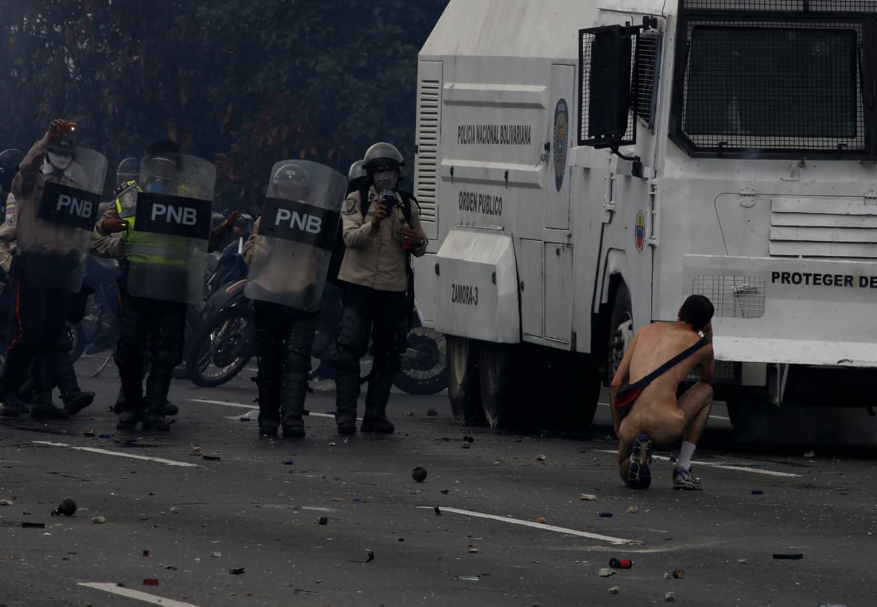 "Le lanzaban una lluvia de bombas, pero él seguía caminando", contó a Univision Noticias Juan Barreto, fotógrafo de AFP. (Carlos García Rawlins/Reuters)