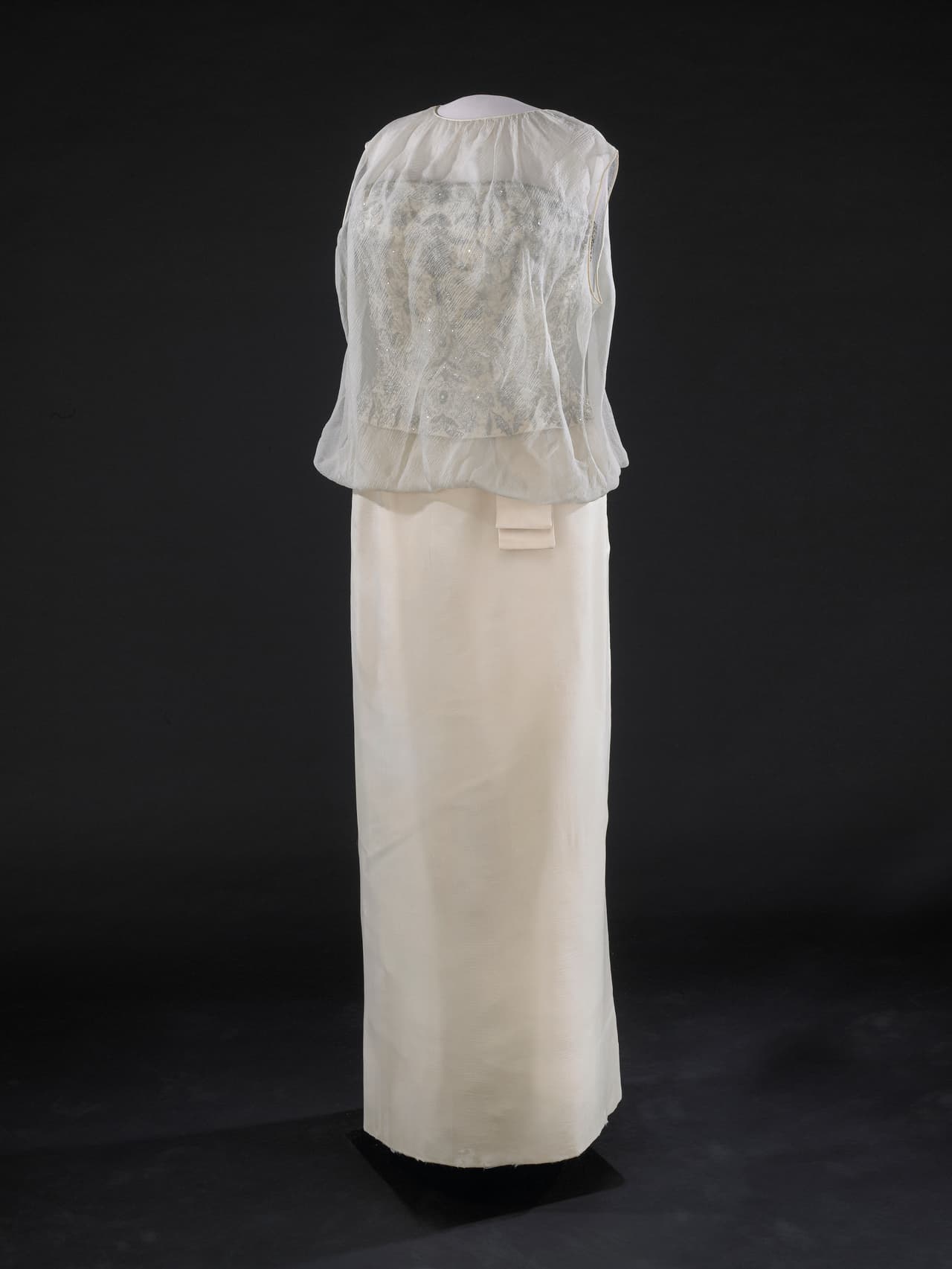 El vestido creado por 
<b>Ethel Frankau de Bergdorf Custom Salon</b> usando los bocetos que le envió la primera dama mantenía una silueta recta muy típica de los años 60 y de la que ella se convertiría en emblema.