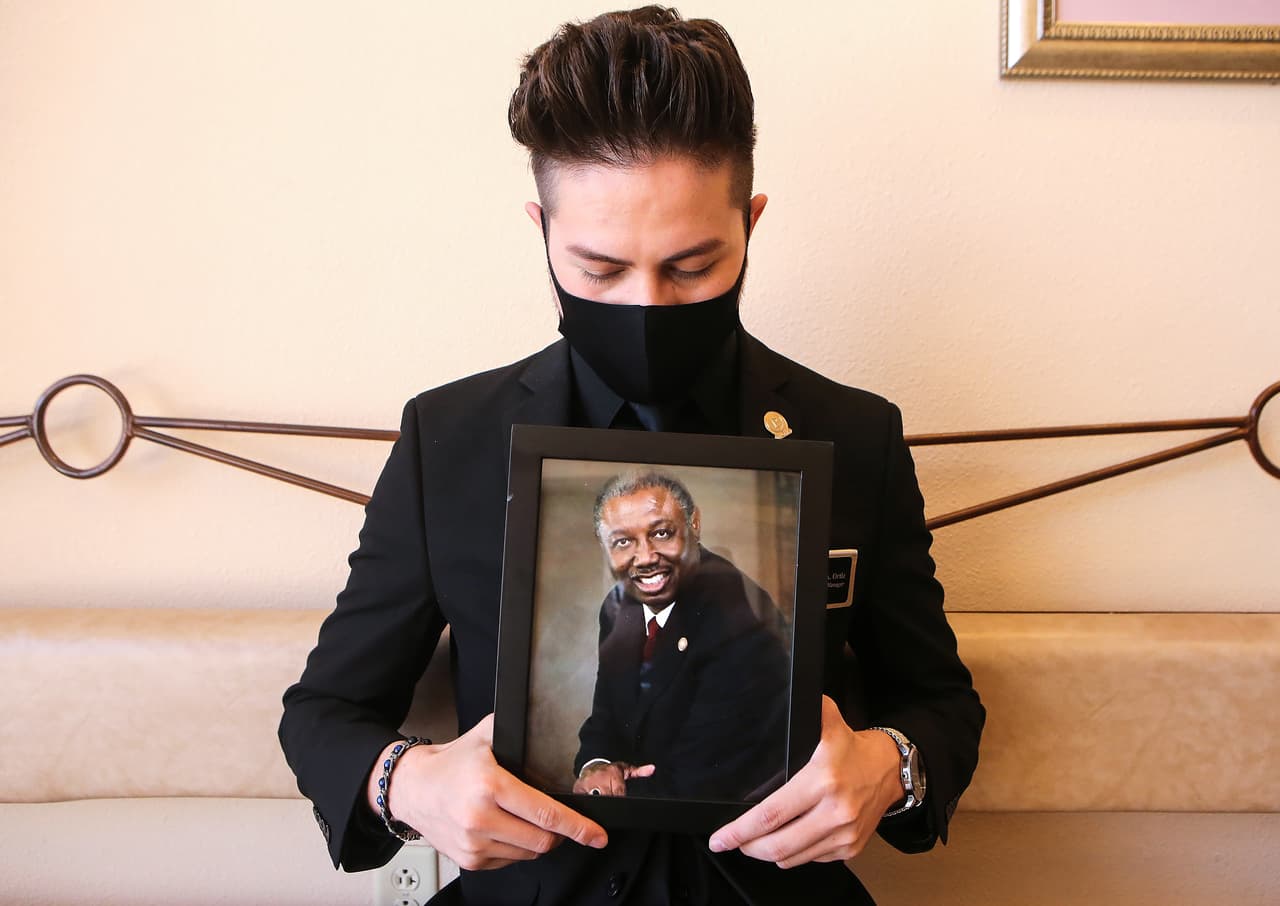 Jorge Ortiz, director de Perches Funeral Homes muestra una foto del pastor Harrison Johnson, quien falleció el 15 de octubre por covid-19, y se desempeñaba como director de funerales en la misma empresa. Johnson encabezó el funeral de una de las víctimas del atentado racista en contra de hispanos el 3 de agosto de 2019.