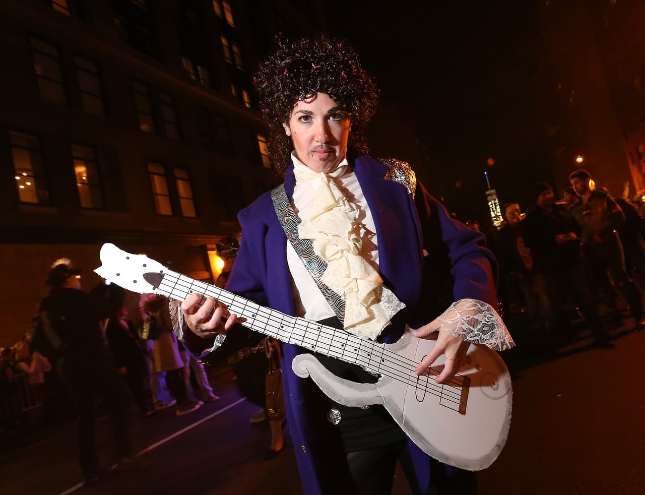 Disfraz de Prince: un saco morado, camisa con hombreras, una especie de guitarra y un bigotillo. Perfecto para los rezagados.